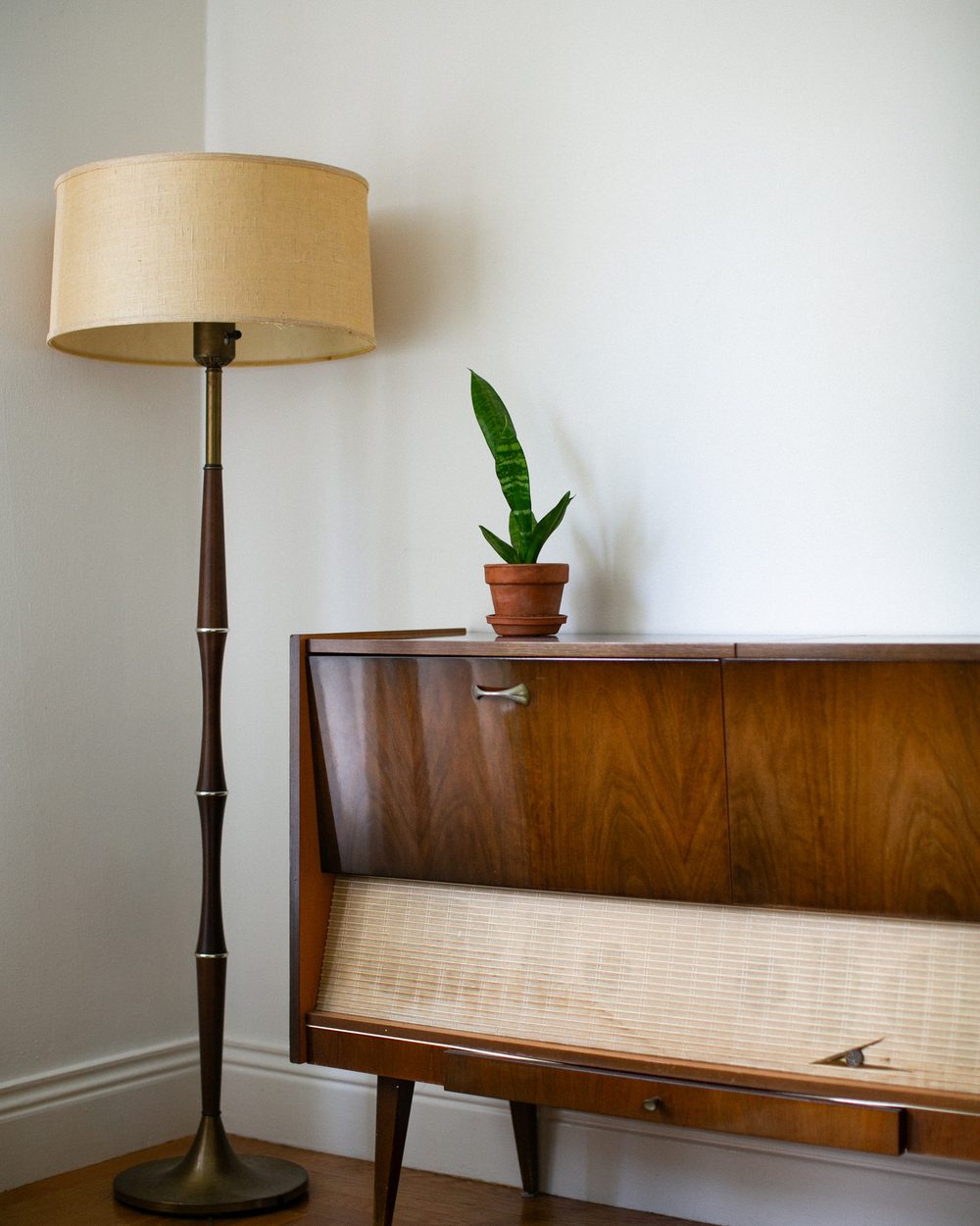 Mid-century floor lamp beside a walnut credenza