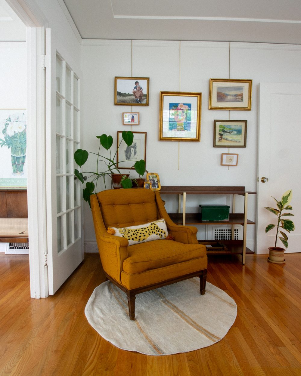 Mustard armchair in front of a gallery wall