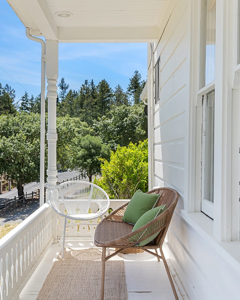 Balcony with woven chairs overlooking trees